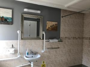 a bathroom with a sink and a mirror at The Cross Guest House in Mablethorpe