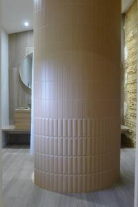 Gîte Château de Peyrel في Prigonrieux: عامود في غرفة مع حمام مع مرآة