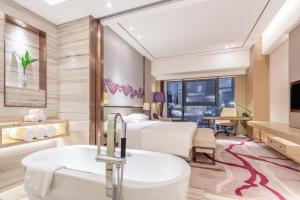 um quarto de hotel com uma cama e uma banheira em Crowne Plaza Yibin, an IHG Hotel em Yibin