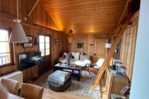a living room with a couch and a tv at Magic Ski-In-And-Out Chalet above Verbier in Bagnes
