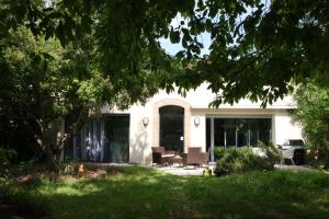 Casa blanca con sillas y mesa en La Closerie aux Violettes - Maison d'hôtes en Toulouse