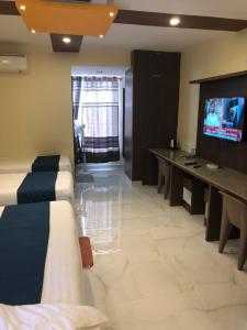 a living room with a couch and a tv in it at Sky Loft near Kempegowda International Airport in Muthugadahalli +24 photos