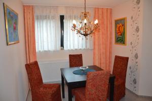 ein Esszimmer mit einem Tisch, Stühlen und einem Kronleuchter in der Unterkunft Ferienwohnung in Fuhlenbrock in Bottrop