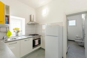 a white kitchen with a sink and a refrigerator at ALLA CASA ROSA RAPALLO, Peaceful Multiple Apartment Surrounded by Greenery with Free Parking, WiFi & Air Conditioning in Rapallo +88 photos