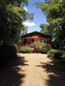 una casa in mezzo a un cortile con alberi di Gîte Les Hortensias a Vaas