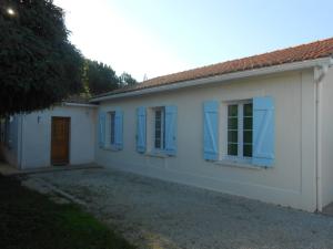 a white house with blue shutters on it at SYLCHRISVACANCES in Vaux-sur-Mer