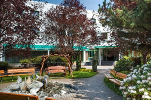 a park with benches in front of a building at Hotel Partner in Warsaw