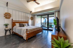 a bedroom with a bed and a television and a balcony at HBR Suite 9304, 5, 6 in Princeville