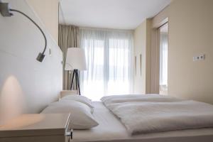 a bedroom with two beds and a window at Falkensteiner Residences Senia in Petrcane