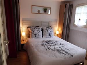 a bedroom with a bed and two lamps and a window at Gîte Les Hortensias in Vaas