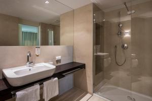 La salle de bains est pourvue d'un lavabo et d'une douche. dans l'établissement Falkensteiner Residences Senia, à Petrčane