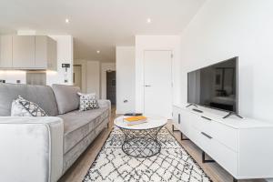 ein Wohnzimmer mit einem Sofa, einem TV und einem Tisch in der Unterkunft Seven Living Residences Solihull - Close to NEC & BHX - Free Parking in Solihull