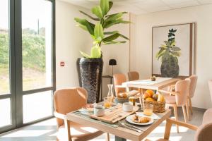 a dining room with a table with food on it at Zenao Appart'hôtels Villeneuve-lès-Avignon in Villeneuve-lès-Avignon