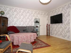 a living room with a couch and a tv on a wall at Condis Lägenheten in Järvsö