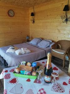 Schlafzimmer mit einem Bett und einem Tisch mit einer Flasche Champagner in der Unterkunft Charmant Chalet pour 2 personnes SPA privé in Massillargues-Attuech