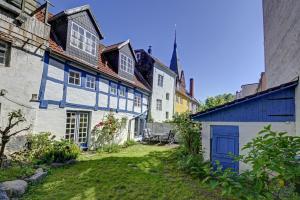 eine Gruppe von Häusern mit blauen Türen und einem Hof in der Unterkunft fewo1846 - Villa Windschief - uriges Fachwerkhaus auf 3 Ebenen mit Garten im Stadtzentrum in Flensburg