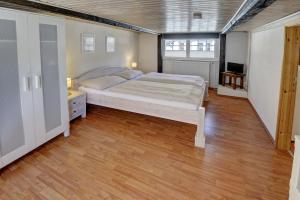 a bedroom with a large bed and a wooden floor at fewo1846 - Villa Windschief - uriges Fachwerkhaus auf 3 Ebenen mit Garten im Stadtzentrum in Flensburg