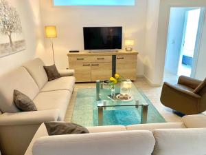 un soggiorno con divano bianco e TV di fewo1846 - Atrium - luxuriöse Wohnung mit 3 Schlafzimmern und Balkon im Stadtzentrum a Flensburgo