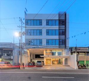 een groot wit gebouw met auto's geparkeerd voor het bij Hotel Inigo in Legazpi