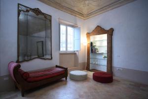 sala de estar con banco y espejo en Palazzo Santinelli, en SantʼAngelo in Vado