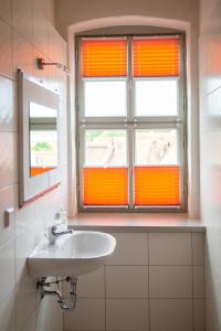 a bathroom with an orange window and a sink at Pension Schloss Heringen in Heringen