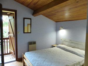 sypialnia z łóżkiem i drewnianym sufitem w obiekcie Villa Paloma Pour 8 Personnes w mieście Soorts-Hossegor