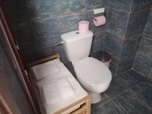 a bathroom with a toilet and a stool with a roll of toilet paper at LAOUTARIS INN in Panayia +28 photos