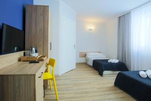 a room with two beds and a desk with a television at Centrum Sportu i Rekreacji in Sępólno Krajeńskie