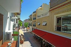a city street with buildings and a red awning at Lavander in Sitges