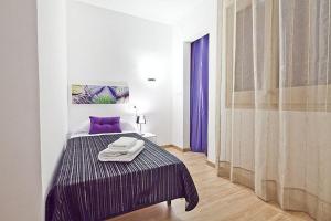 a bedroom with a bed with purple sheets and a purple pillow at Lavander in Sitges
