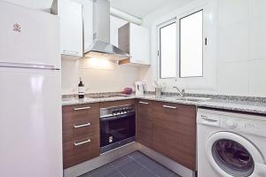 a white kitchen with a washer and a dishwasher at Lavander in Sitges