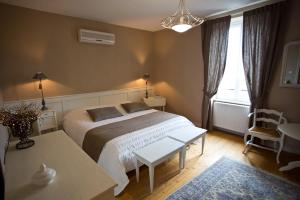 - une chambre avec un lit, une table et une fenêtre dans l'établissement Domaine VIOLOT-GUILLEMARD, à Pommard
