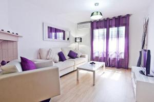 a living room with a white couch and purple pillows at Lavander in Sitges +3 photos