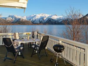 a patio with a table and a grill and mountains at 5 person holiday home in Laukvik in Laukvik