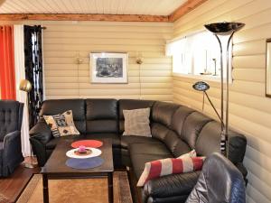 uma sala de estar com um sofá de couro e uma mesa em 5 person holiday home in Laukvik em Laukvik