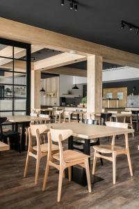 een restaurant met tafels en stoelen en een keuken bij Tylickie Wzgórze Spa & Wellness pensjonat dla rodzin z dziećmi in Tylicz