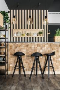 een keuken met twee zwarte krukken voor een aanrecht bij Tylickie Wzgórze Spa & Wellness pensjonat dla rodzin z dziećmi in Tylicz