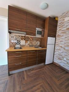 a kitchen with wooden cabinets and a white refrigerator at Precioso ático en el casco antiguo de Triana in Seville