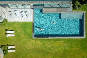 eine Aussicht auf einen Pool mit 2 Personen Schwimmen in der Unterkunft Sporthotel Sonne in Alpe di Siusi