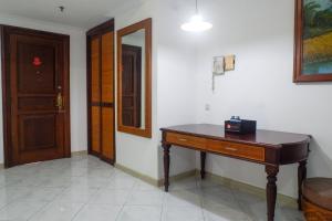 a room with a wooden desk and a door at Spacious Classic 1BR Apartment at Taman Beverly By Travelio in Putat-gede +12 photos