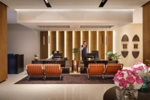a man talking on a phone in an office lobby at Hotel Ambasador - Liburnia in Opatija
