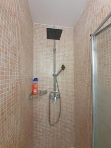 y baño alicatado con ducha y cabezal de ducha. en Precioso ático en el casco antiguo de Triana, en Sevilla