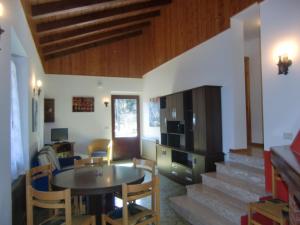 - un salon avec une table, des chaises et des escaliers dans l'établissement Casa Ambra, à Ledro