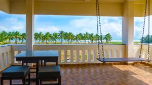 a porch with swings and a view of the ocean at Pranaav Beach Resort in Puducherry