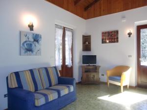 un salon avec un canapé bleu et une chaise dans l'établissement Casa Ambra, à Ledro