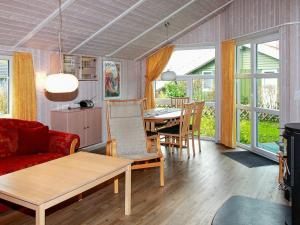 a living room with a red couch and a table at Two-Bedroom Holiday home in Gelting 3 in Gelting