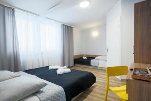 1 dormitorio con 2 camas y silla amarilla en Centrum Sportu i Rekreacji, en Sępólno Krajeńskie