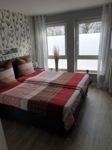 1 dormitorio con 1 cama con manta y 2 ventanas en Gästewohnung BenjaroS, en Chemnitz