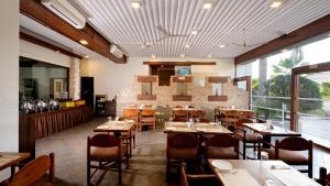ein Speisesaal mit Tischen und Stühlen in einem Restaurant in der Unterkunft Chryso Hotels Pvt Ltd in Ankleshwar