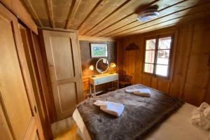 a bedroom with a bed and a table and a window at Magic Ski-In-And-Out Chalet above Verbier in Bagnes